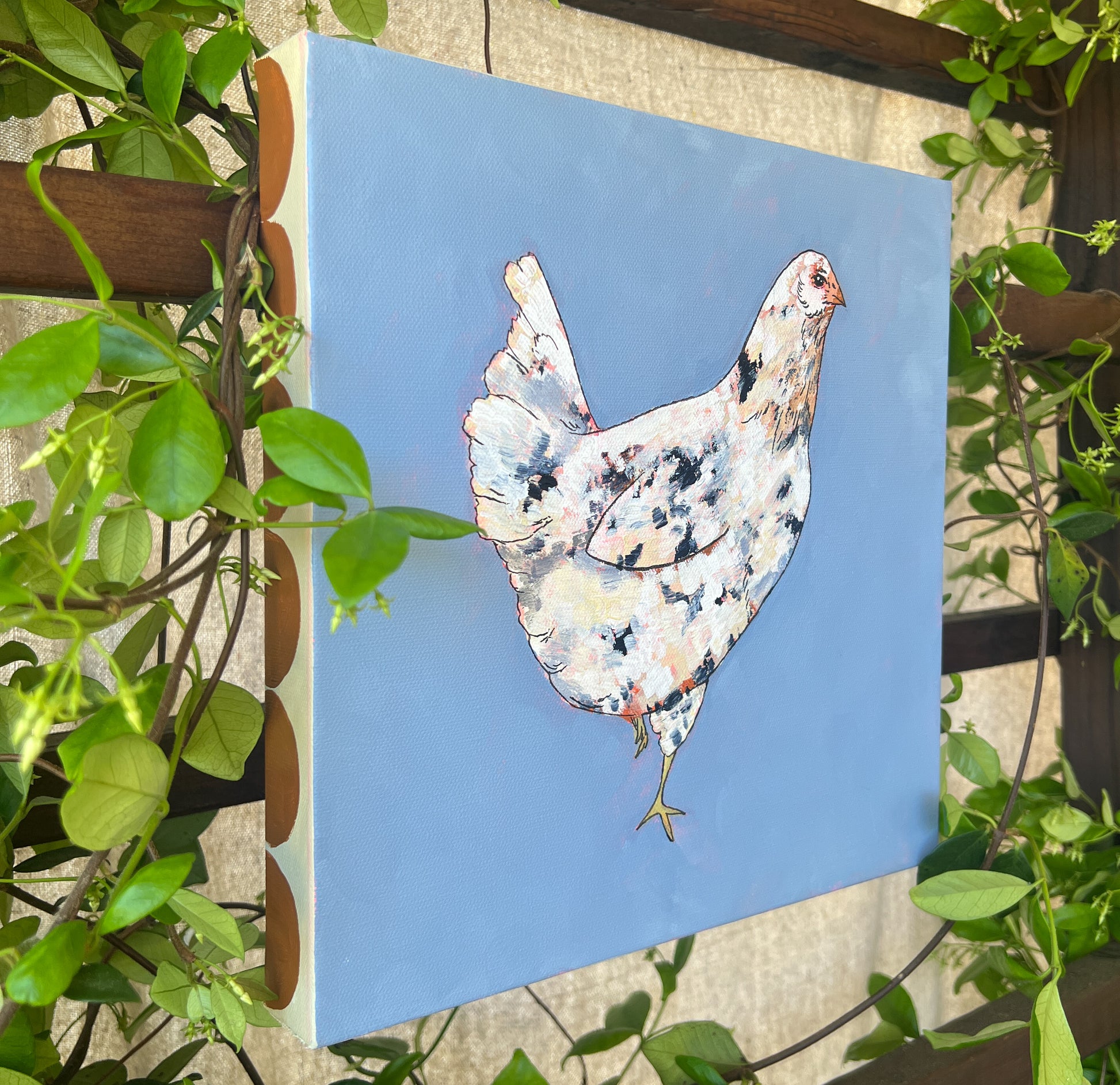 chicken painting with blue background detail and greenery surrounding