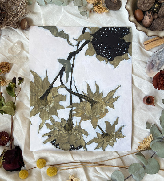 Art print of dried sunflowers with white background. Print is on a white linen cloth with natural dried flowers and other nature items surrounding it.