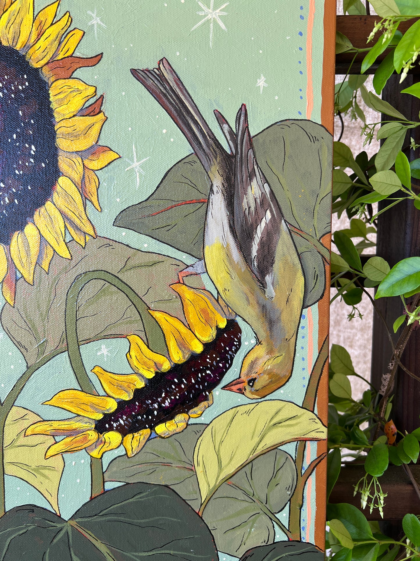 Detail of original painting with female gold finch on sunflowers, surrounded by greenery