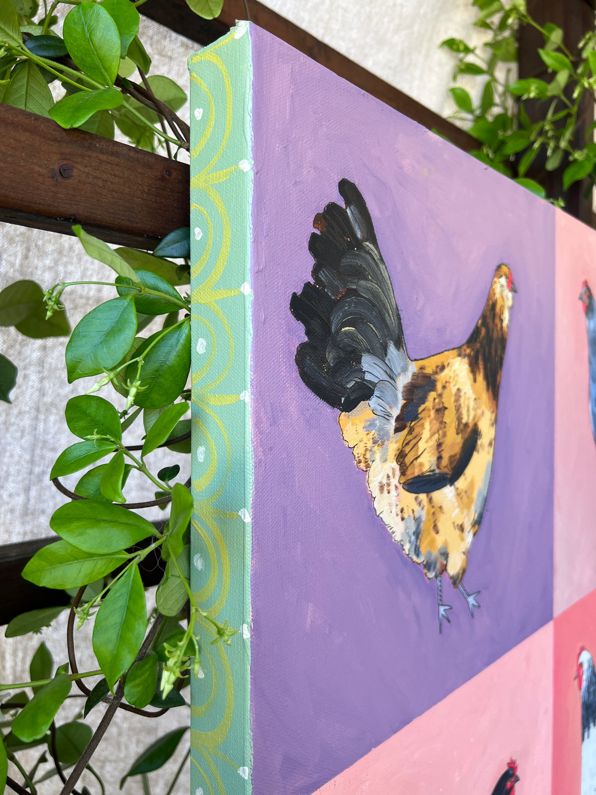Detail of chicken grid painting with colorful backgrounds and greenery surrounding